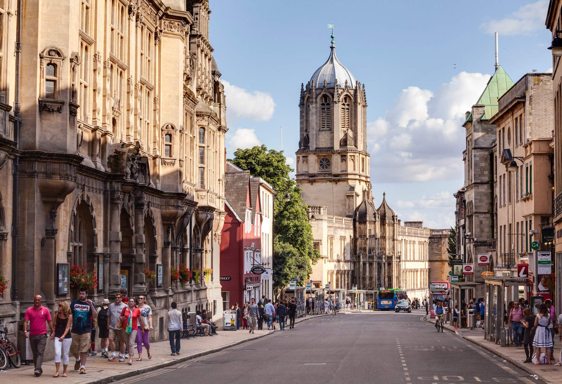 A busy street in Oxford. Christ Church cathedral can be seen rising above the rooftops.