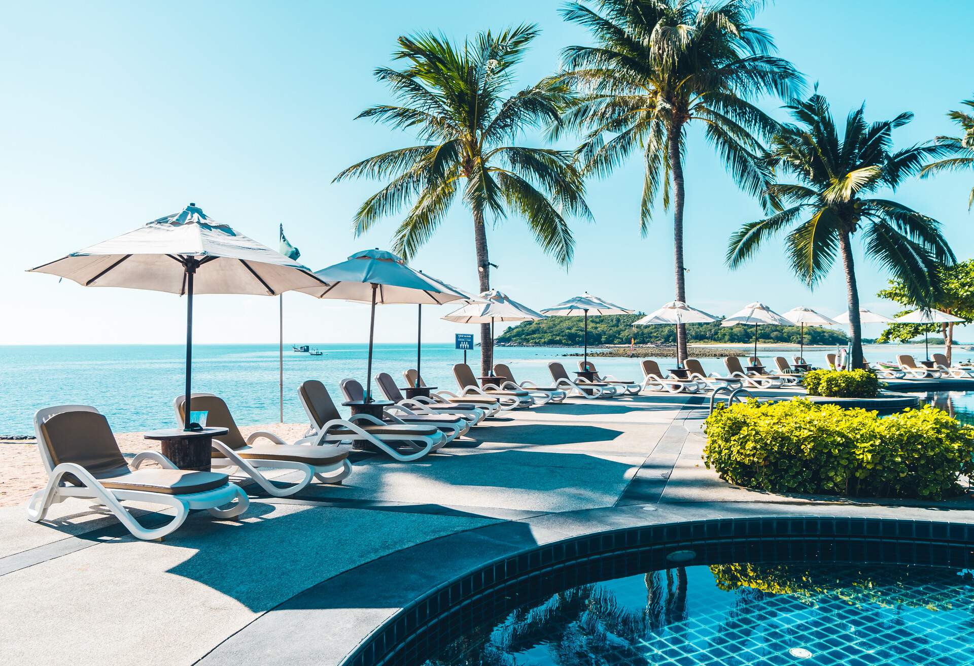 Beautiful tropical beach and sea with umbrella and chair around swimming pool in hotel resort for travel and vacation; Shutterstock ID 1144885448