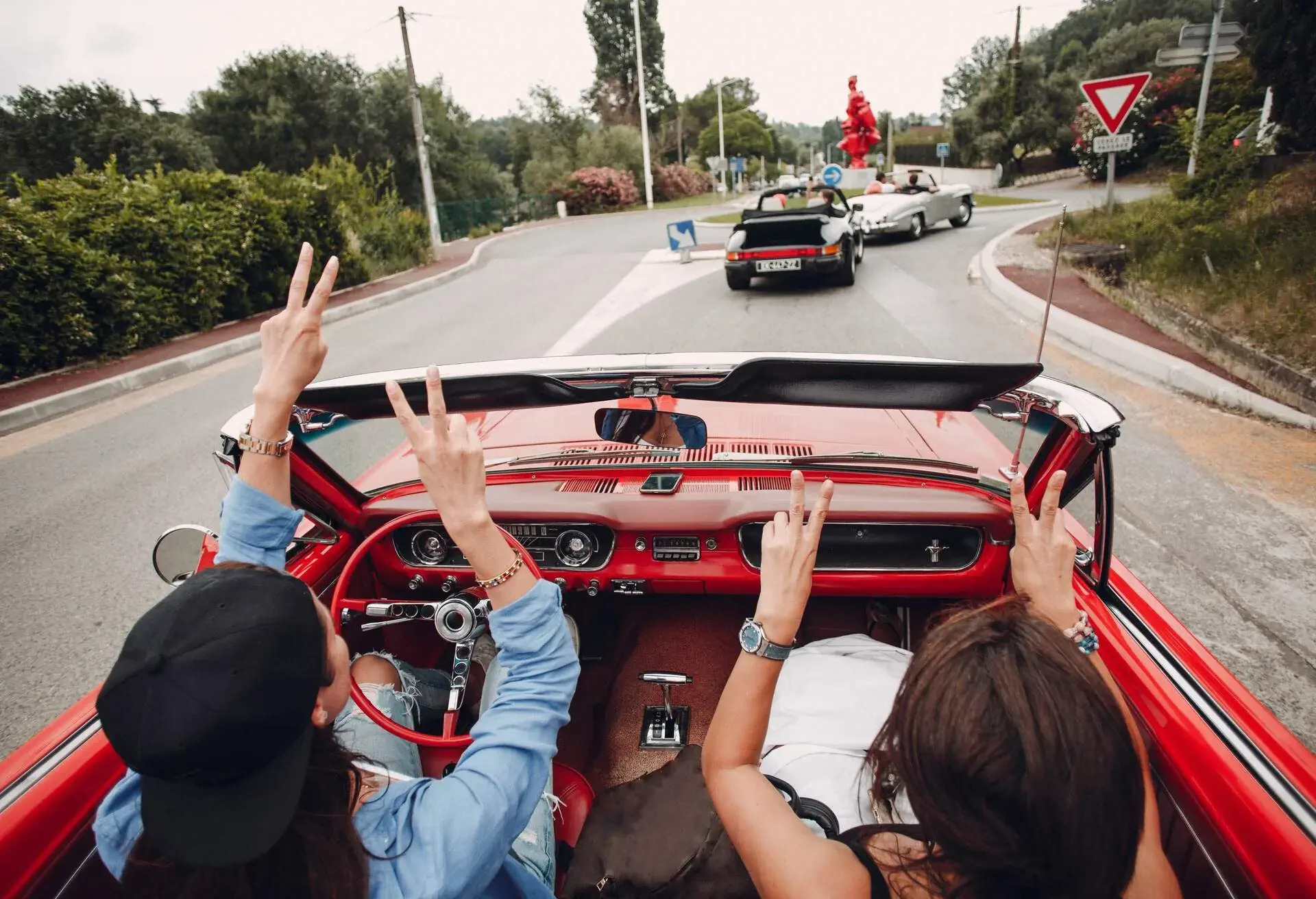 People in a red cabriolet car