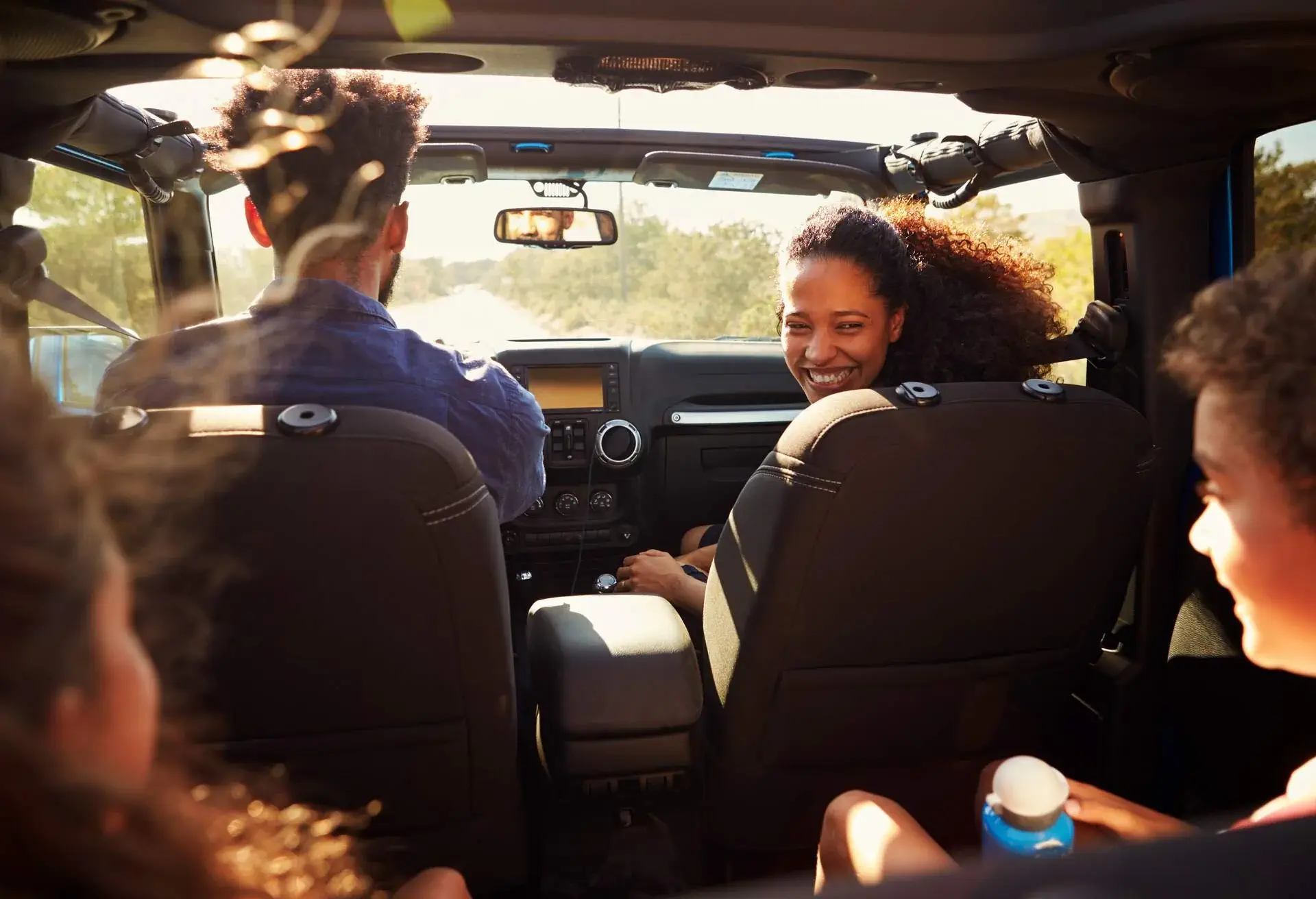 A family in a car, the mother is looking at her kids