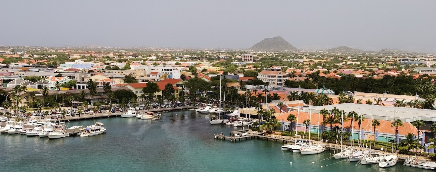 A view of the main harbor on Aruba looking inland. This photo, from a cruise ship, looks down over the city of Oranjestad and boats.