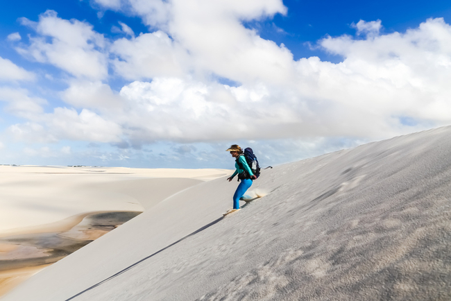 Mulher descendo as dunas no Parque Nacional dos Lençóis Maranhenses