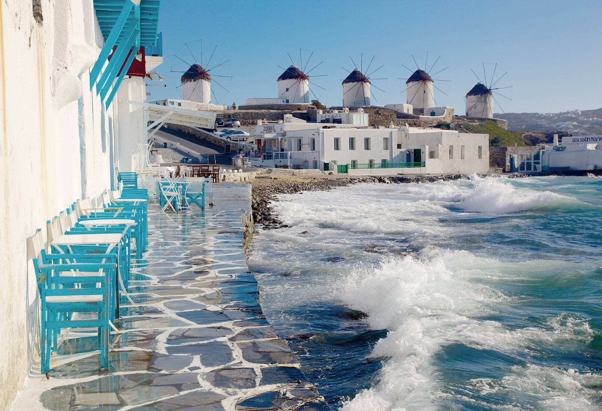 Que tal tomar um café à beira-mar com a paisagem de Mykonos de fundo?