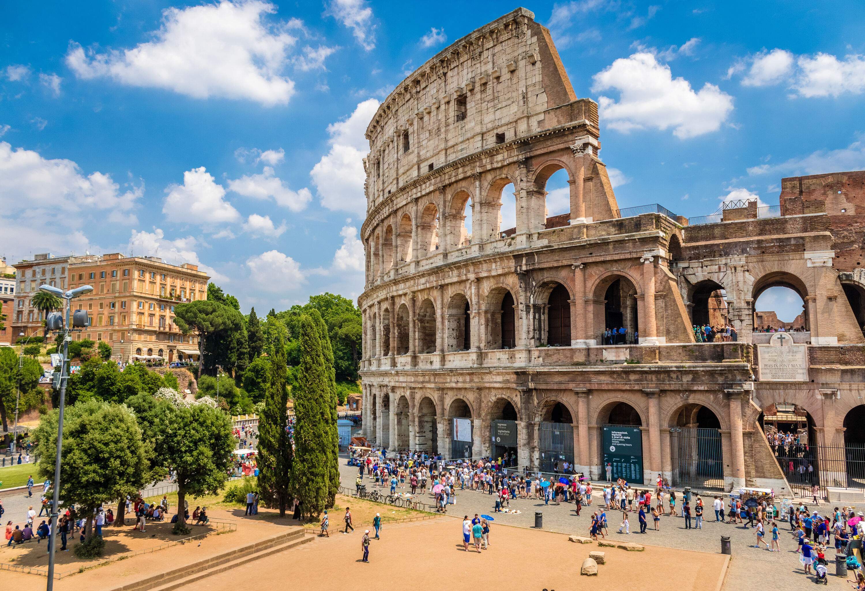 The Colosseum crowded with visitors on a gorgeous bright day.