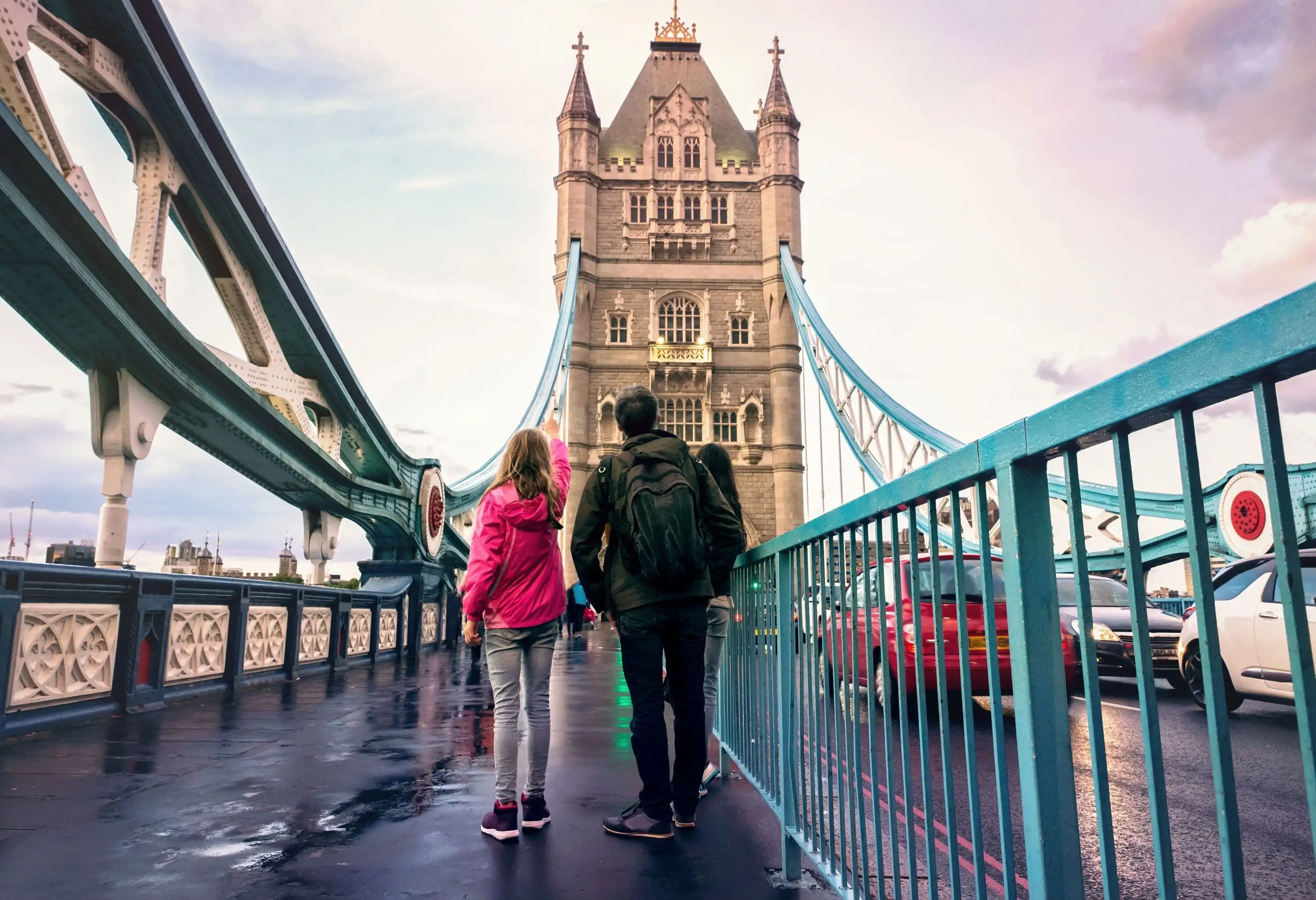 People on the London Bridge looking up at one of the towers.