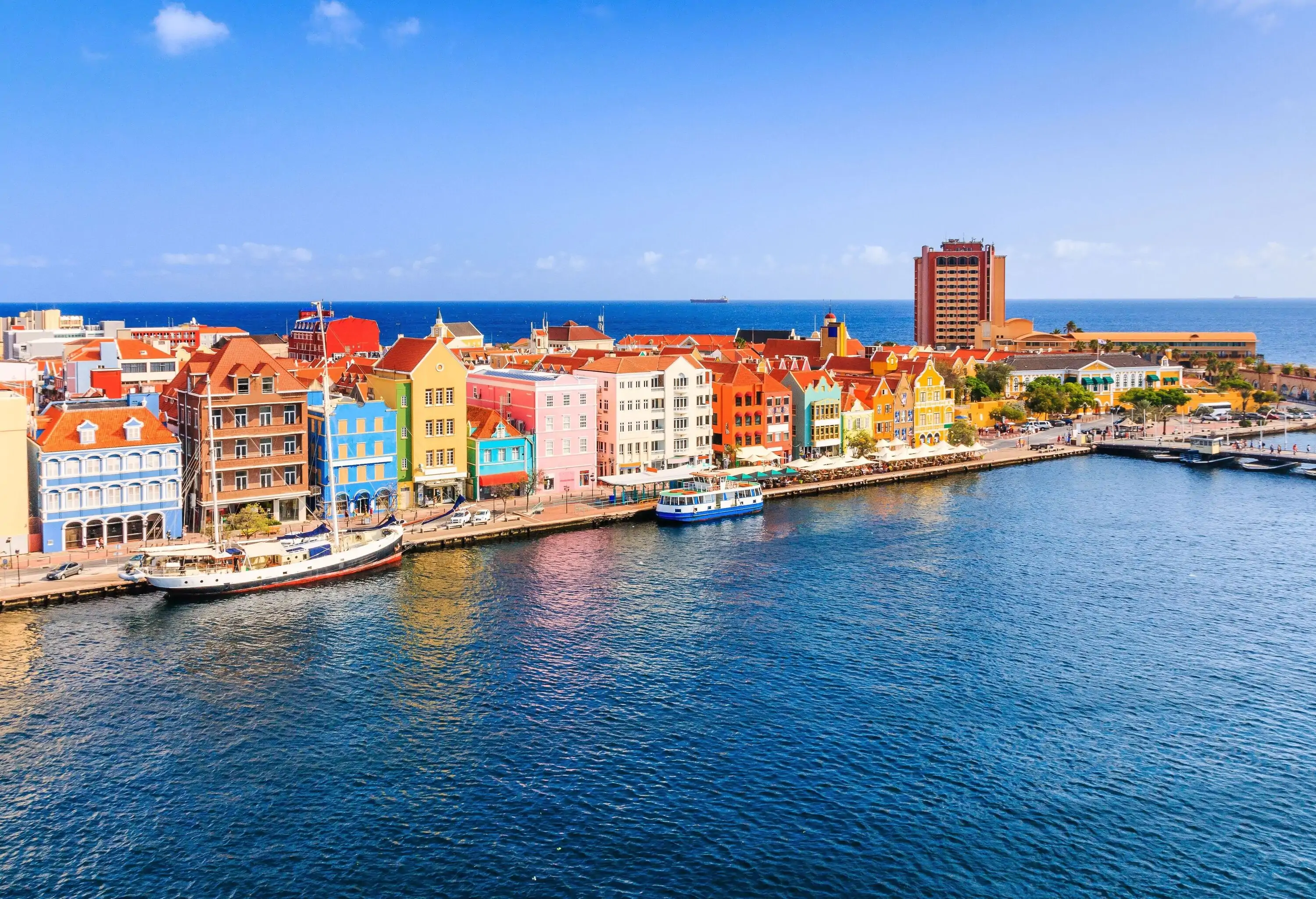 Along the scenic coast, waterfront buildings grace the shoreline, while ferry boats peacefully rest at the moorings by the vibrant promenade.