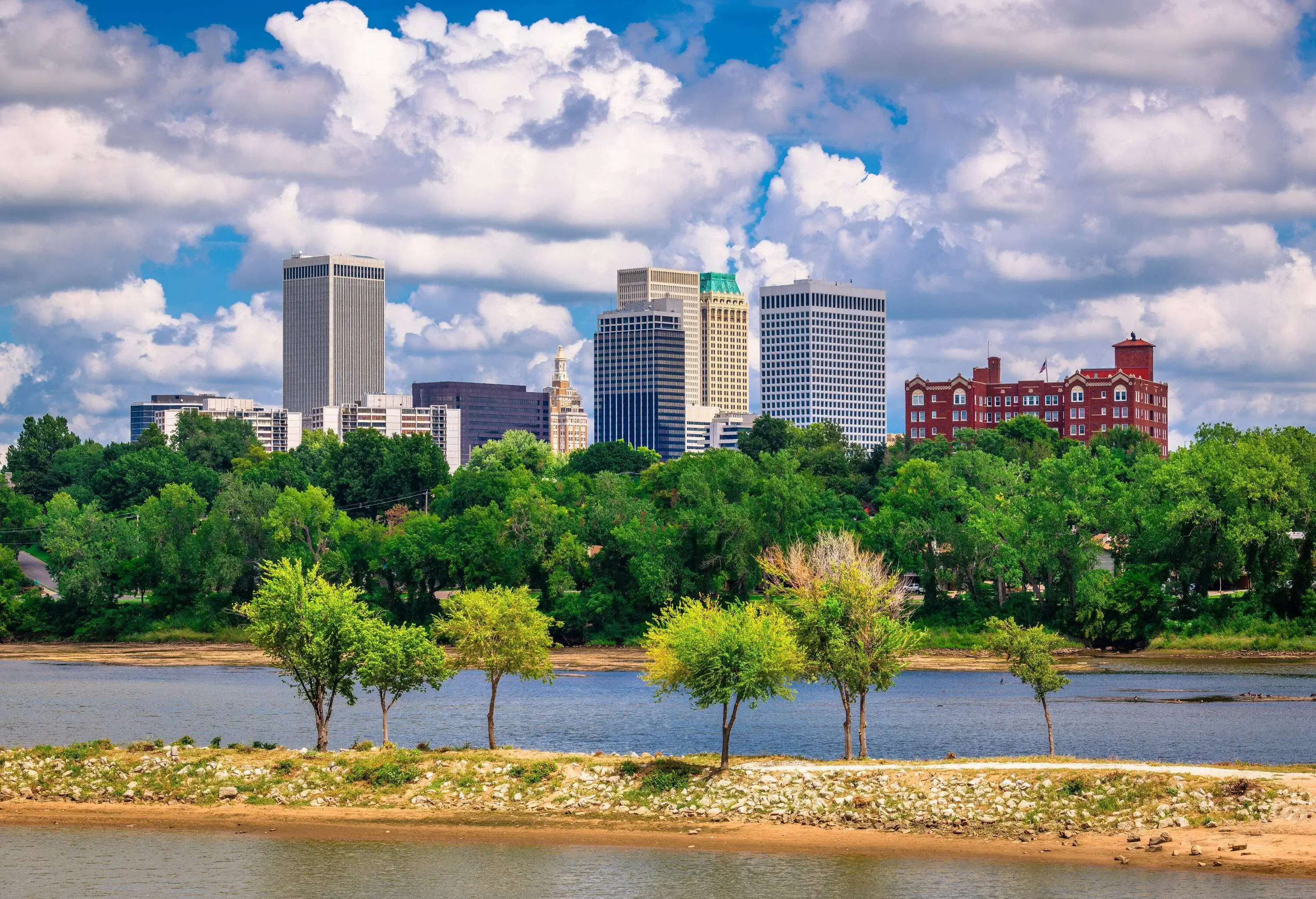 A river across a forested landscape with distant views of the city skyline.