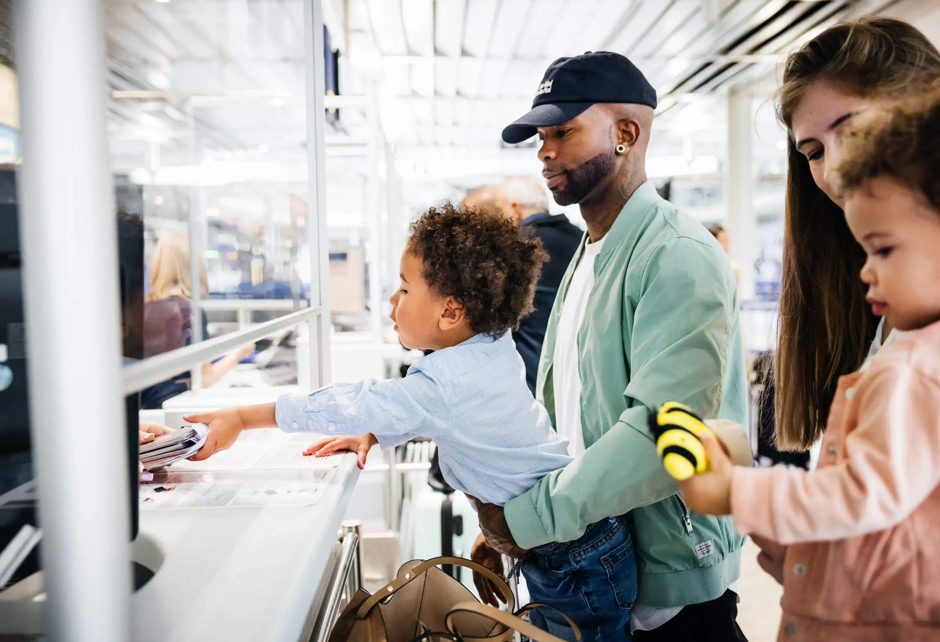 a man and a woman with their two kids in the airport check-in being handed their passports