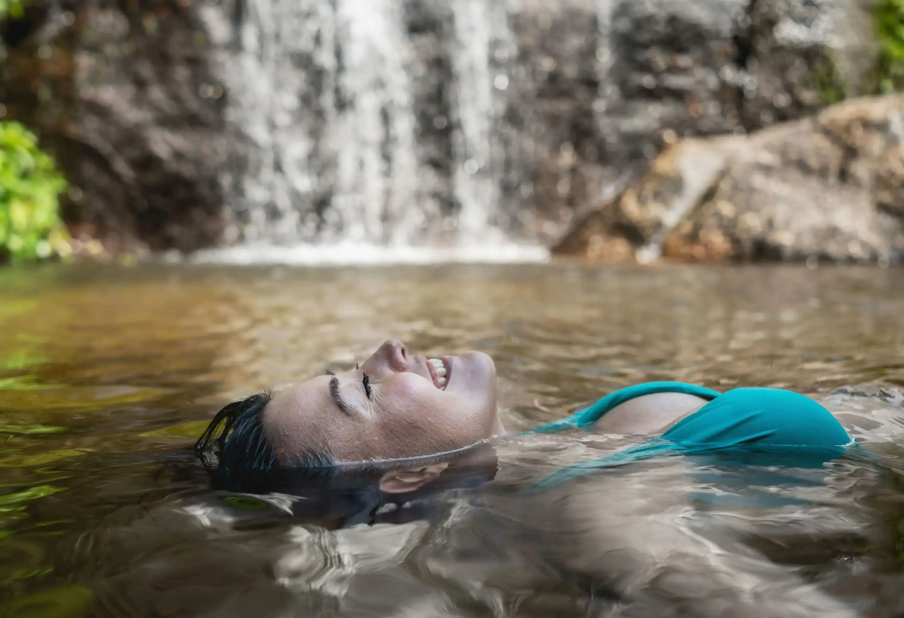 Portrait of a happy woman relaxing and floating in the water â€“ lifestyle concepts