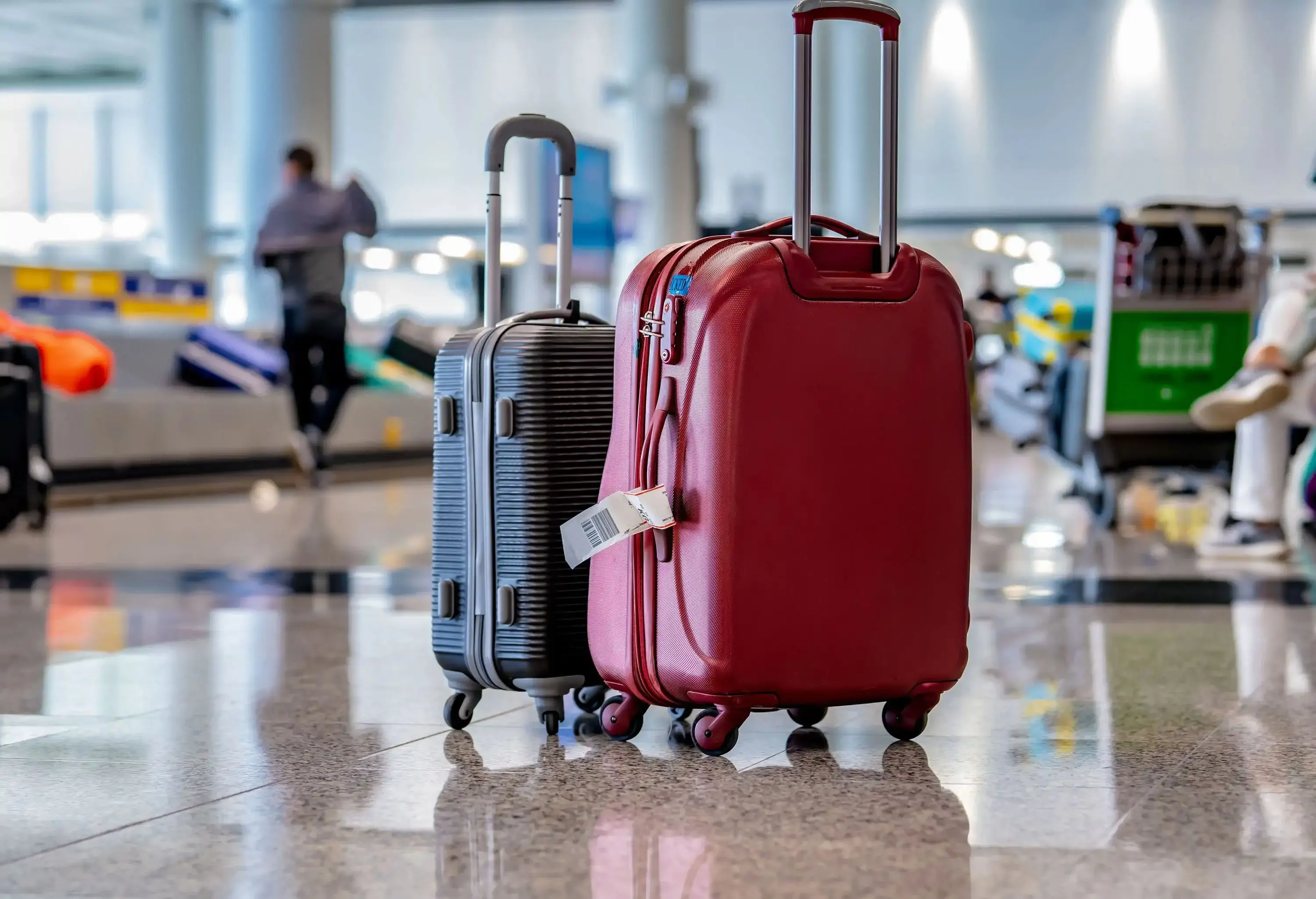 two suitcases standing at the airport close to the baggage claim
