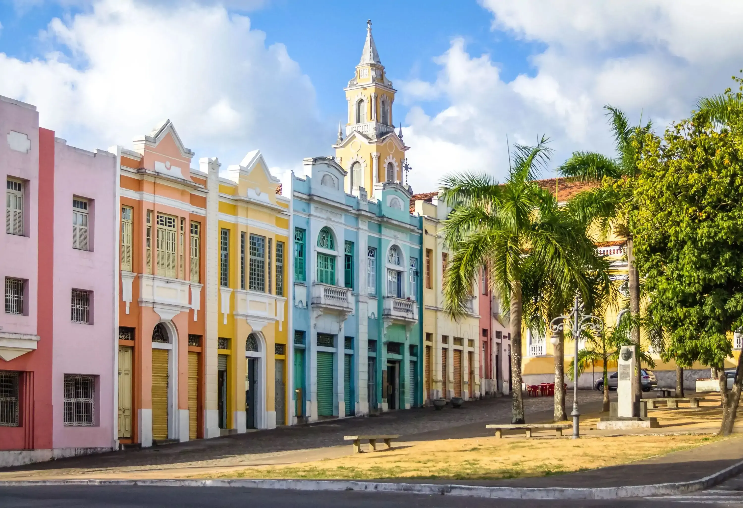 Colourful row of colonial houses in old part of a city with palm trees