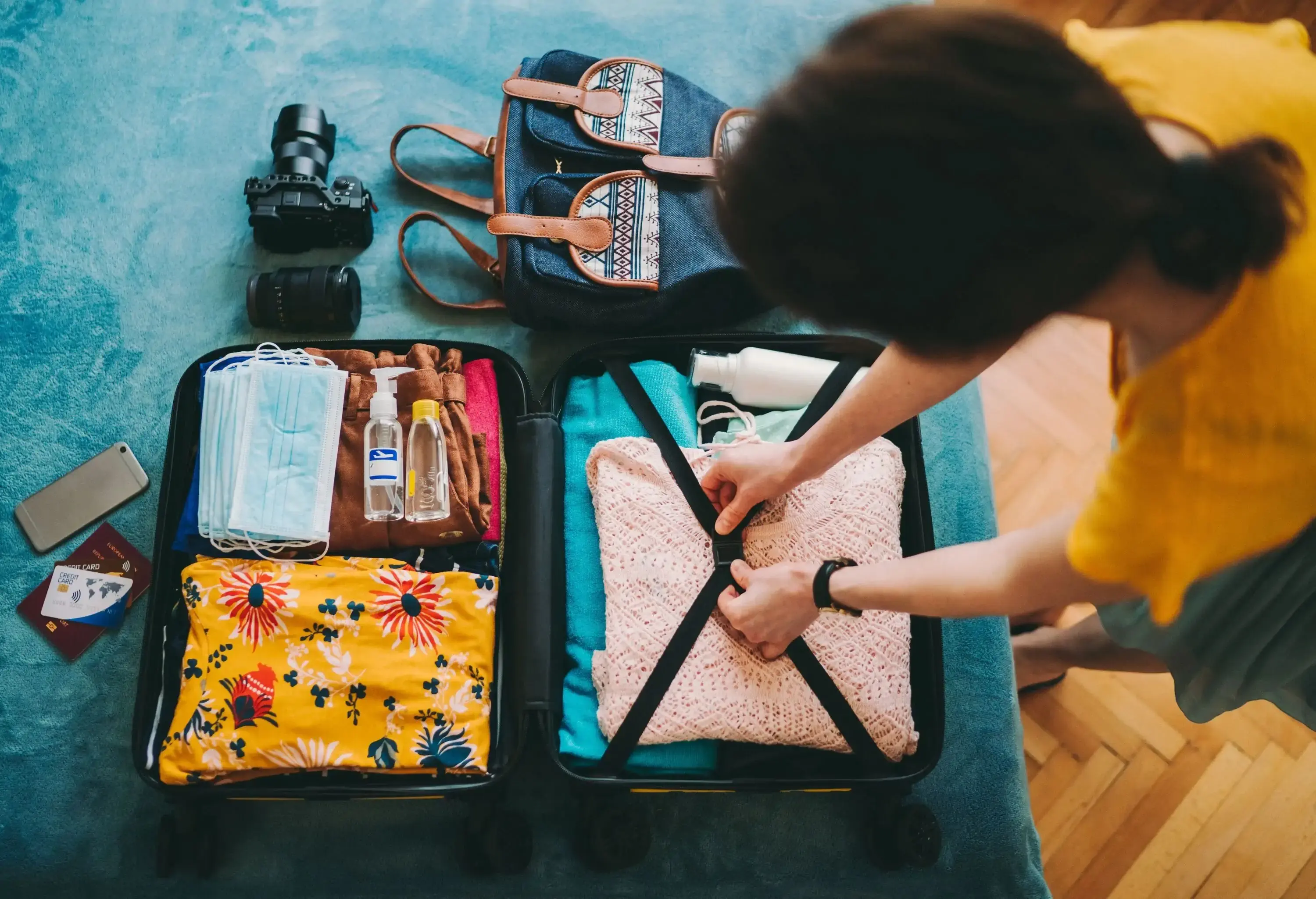 A woman securing the contents of her luggage with the elastic straps.