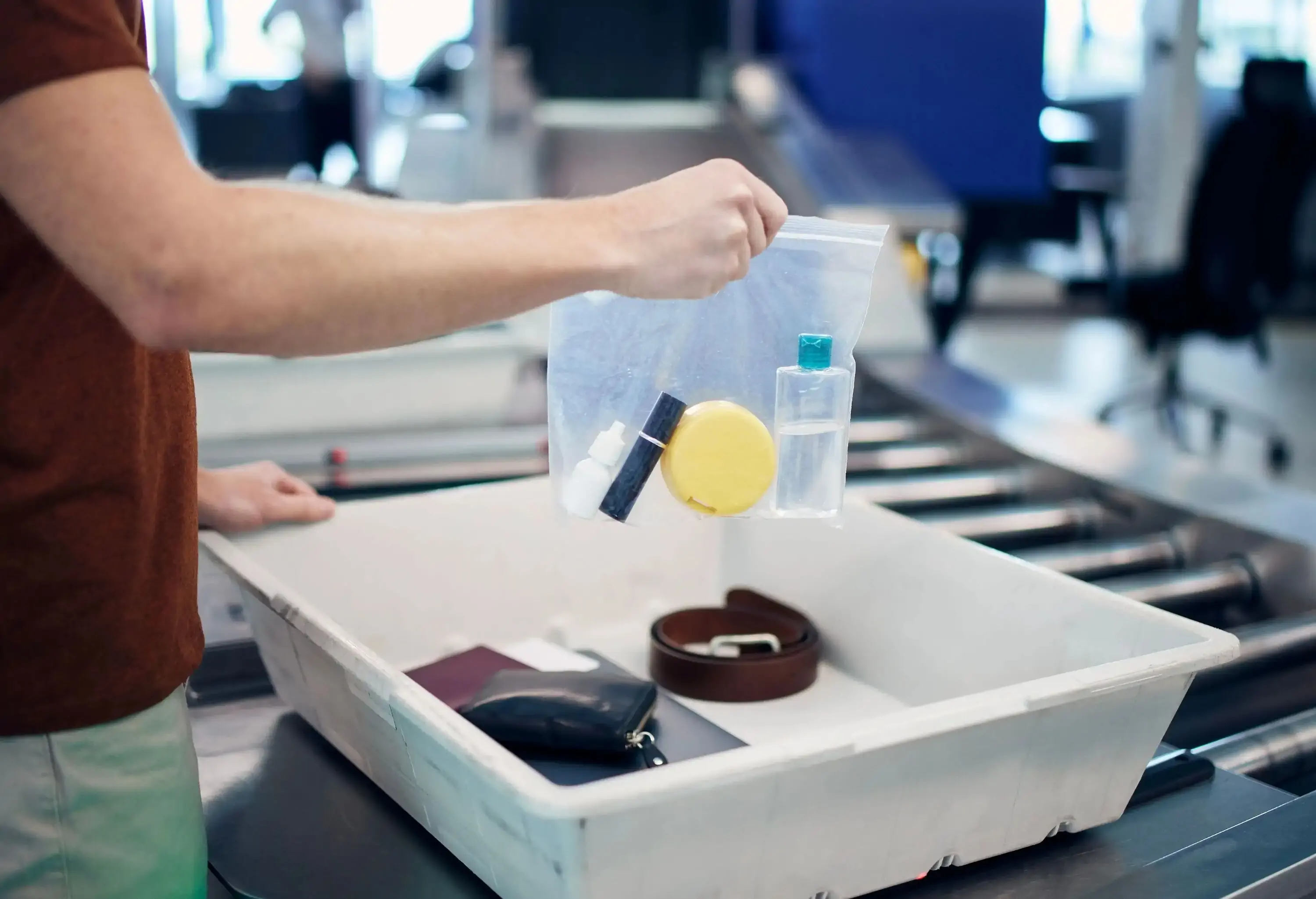 A man packing cosmetics into a plastic bag at airport security