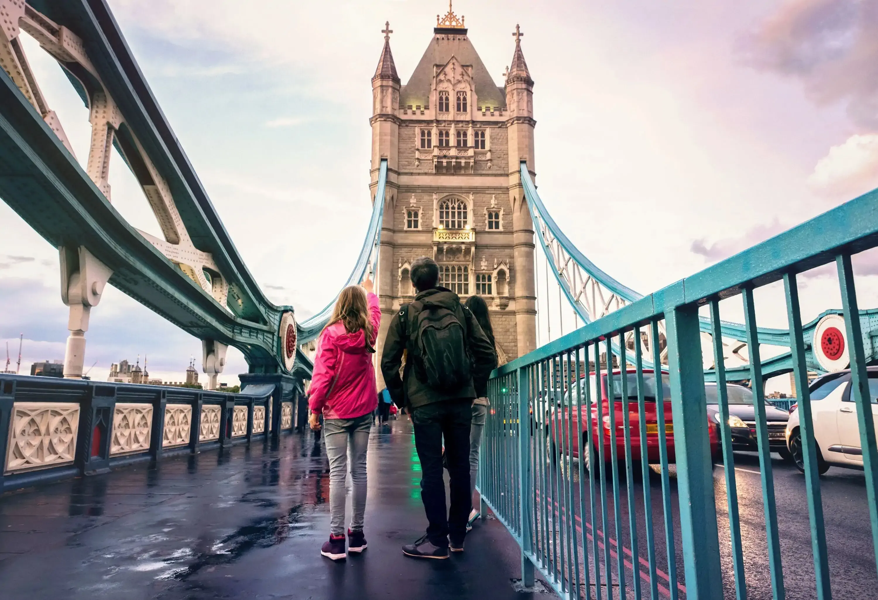 People on the London Bridge looking up at one of the towers.