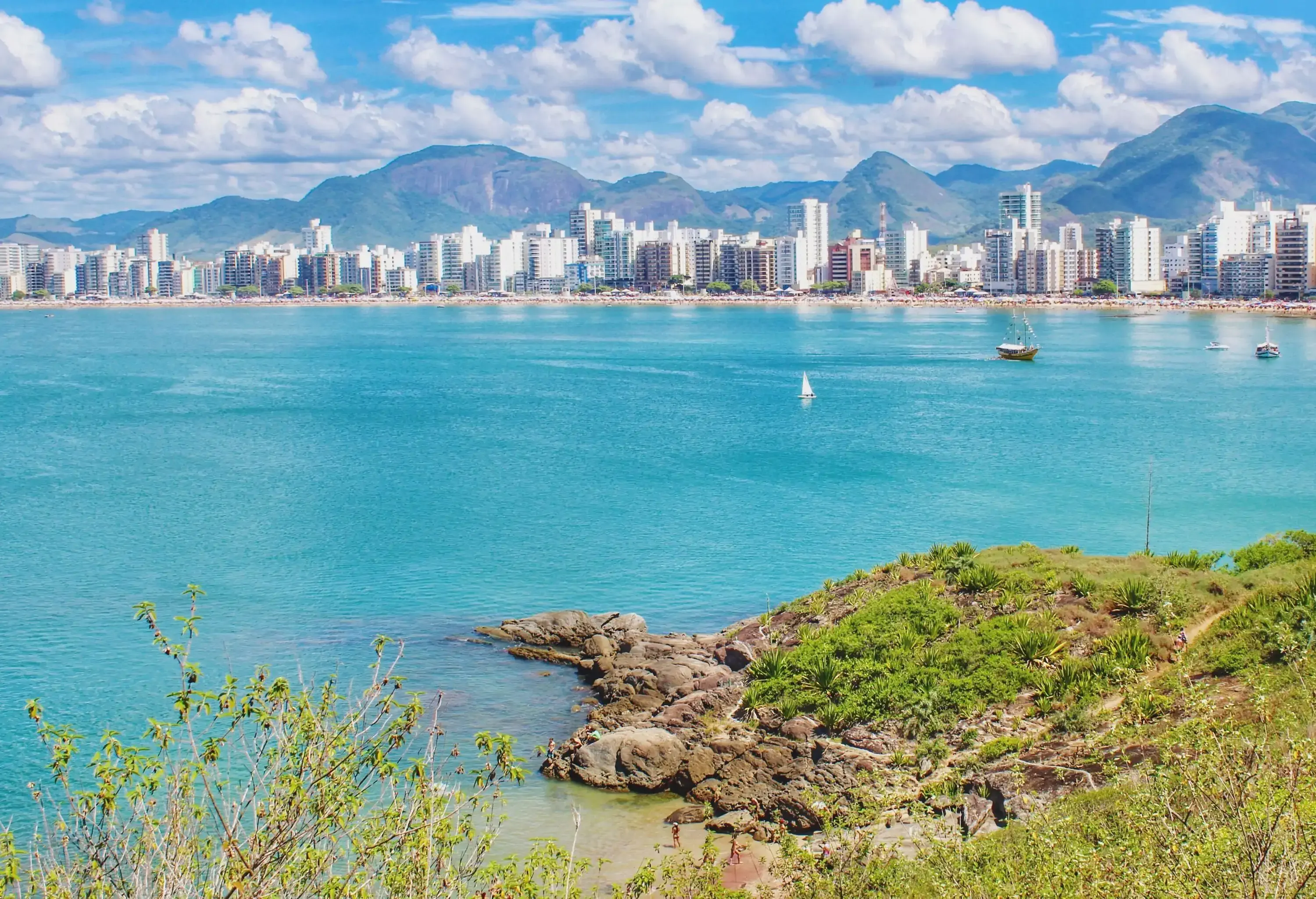 A vast ocean along a coastal town with a row of high-rise buildings.