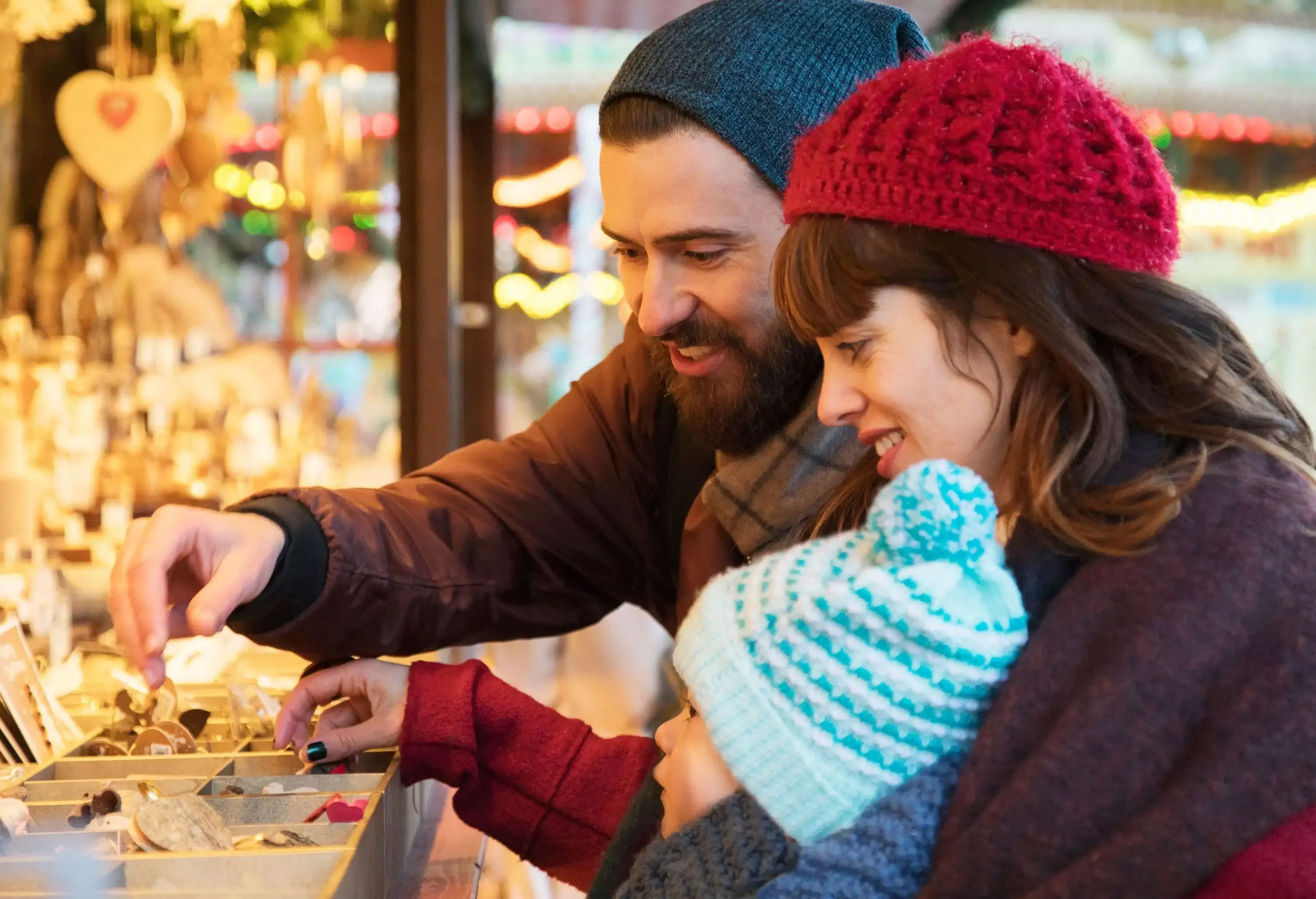 Family with toddler looking at trinkets at a Christmas market