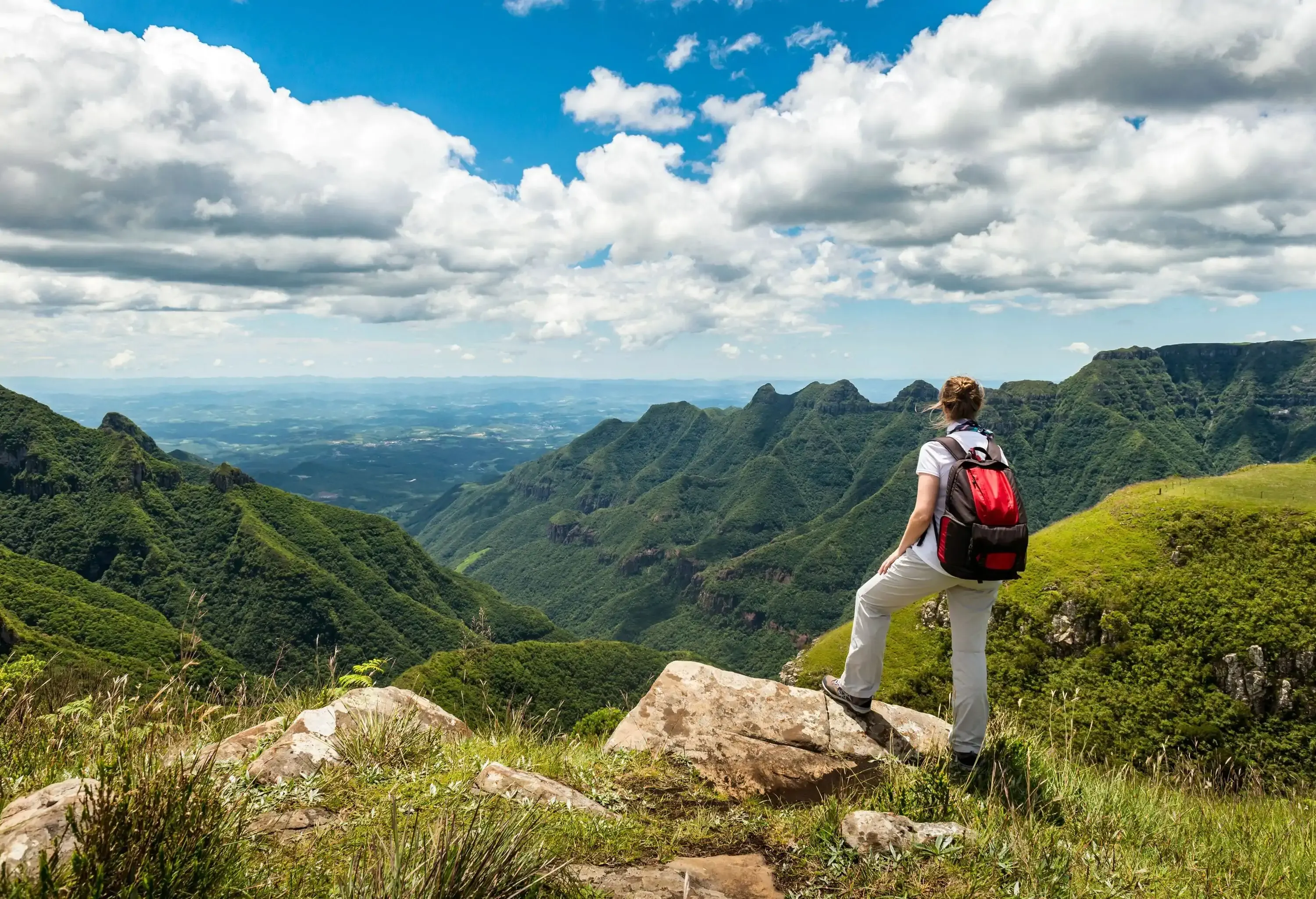 Hiker looking at green mountain range and canyon