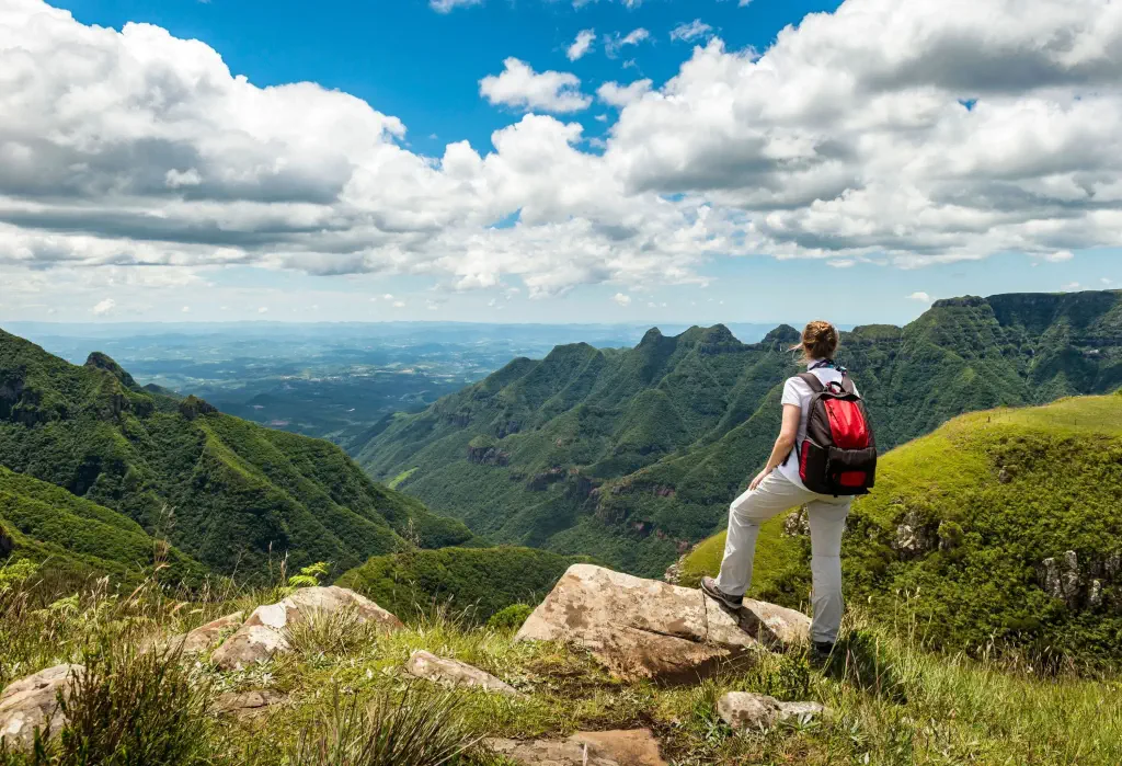 Hiker looking at green mountain range and canyon