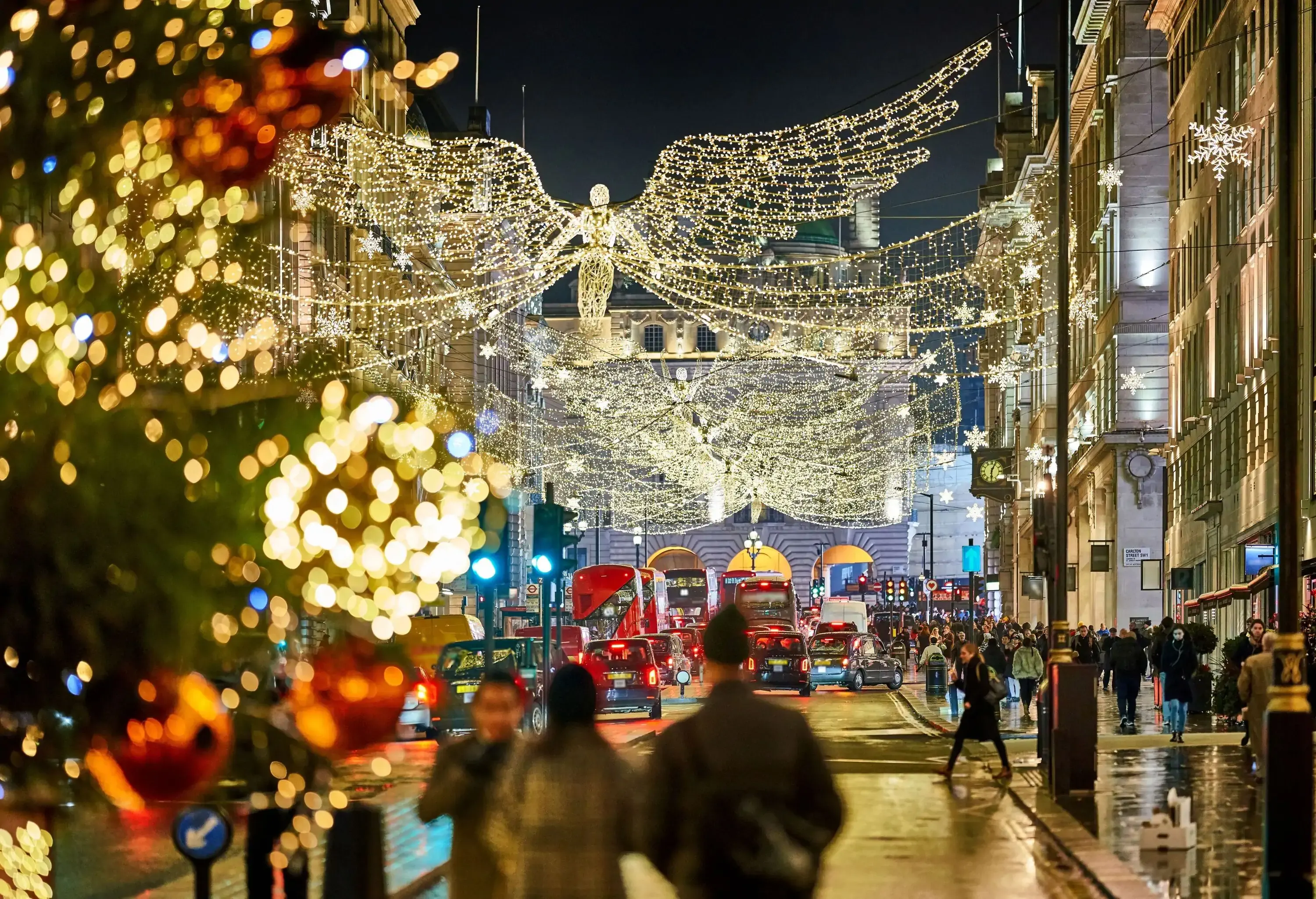 Christmas lights on large city avenue on a busy evening