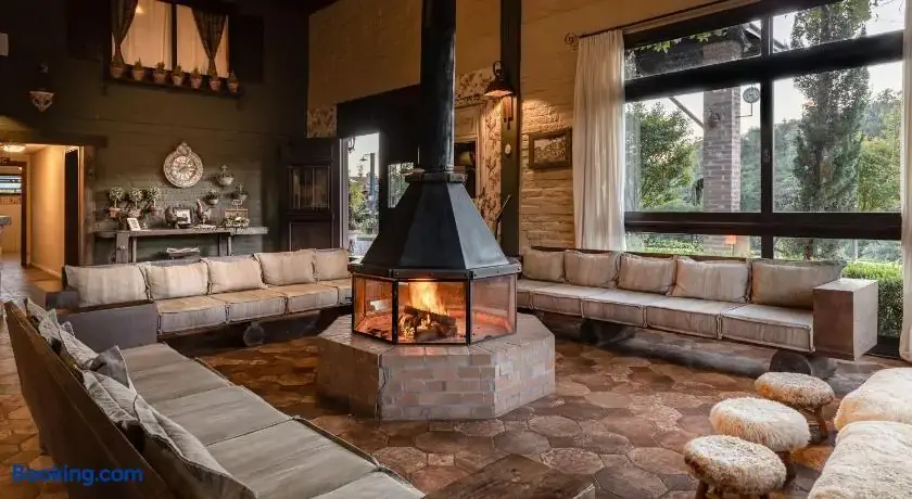 Rustic lobby of a farmhouse hotel with roaring fire pit in the middle of the room