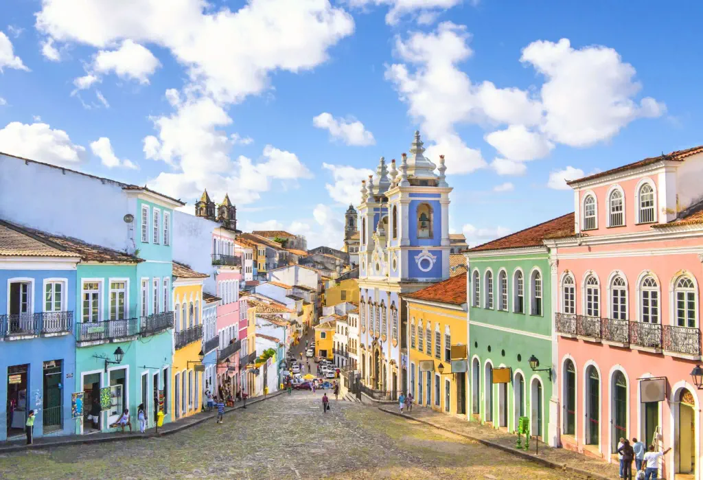 Colourful historic structures lining both sides of a sloping street.
