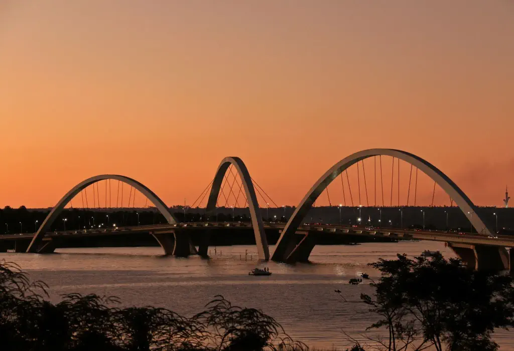 The Juscelino Kubitschek Bridge, a modern marvel of engineering, features three graceful arches that elegantly span the distance, supported by iron cables that add both strength and aesthetic appeal.