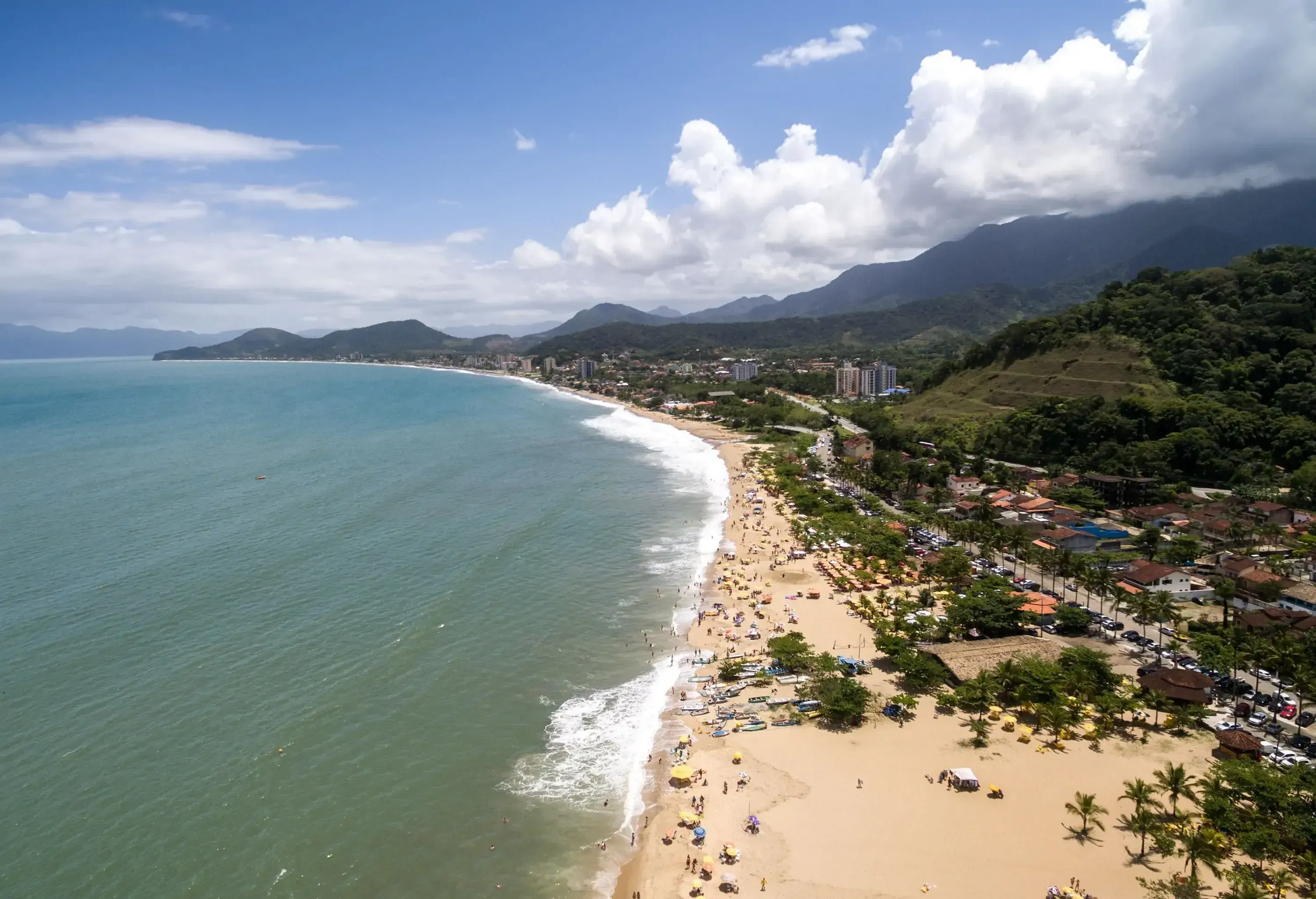 Aerial view of an urban coastal city with a sandy beach surrounded by the tranquil sea.