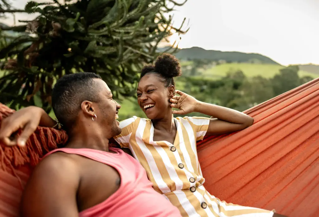 LGBTQIA+ friends lying on hammock on house yard