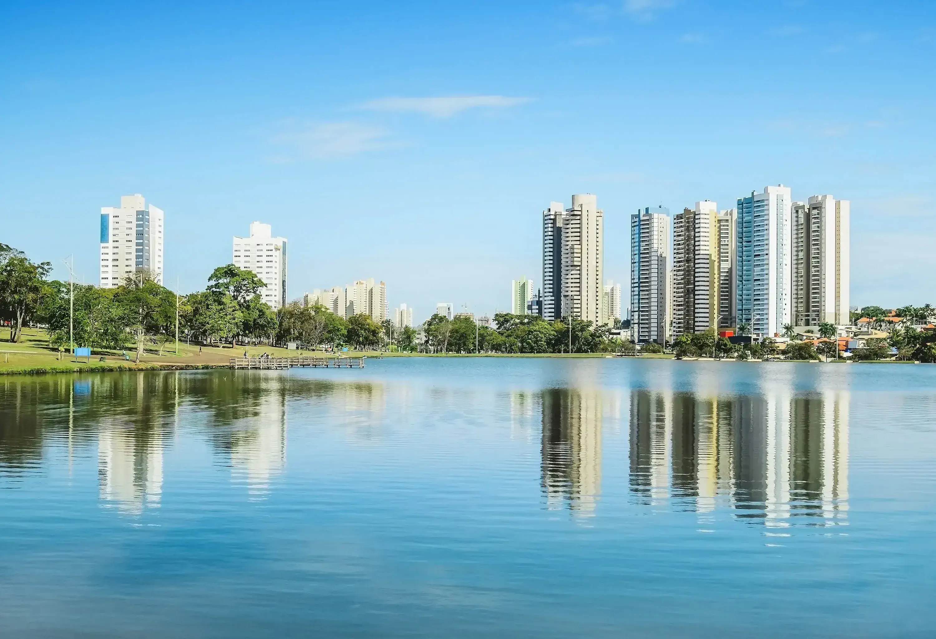 The city skyline and lush surroundings of the lake are reflected in its water.