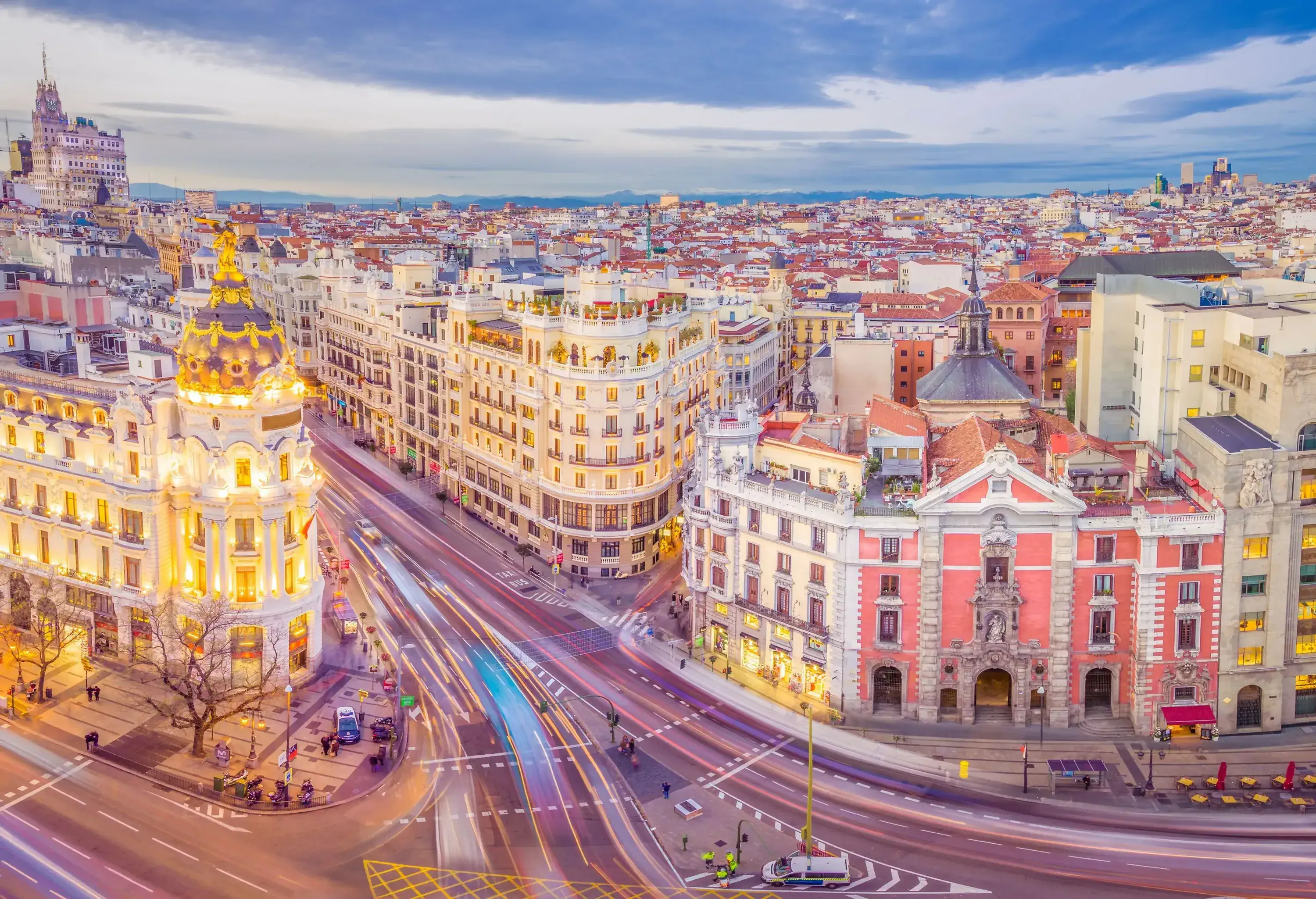 Lavish structures along the streets with moving cars creating light streaks.