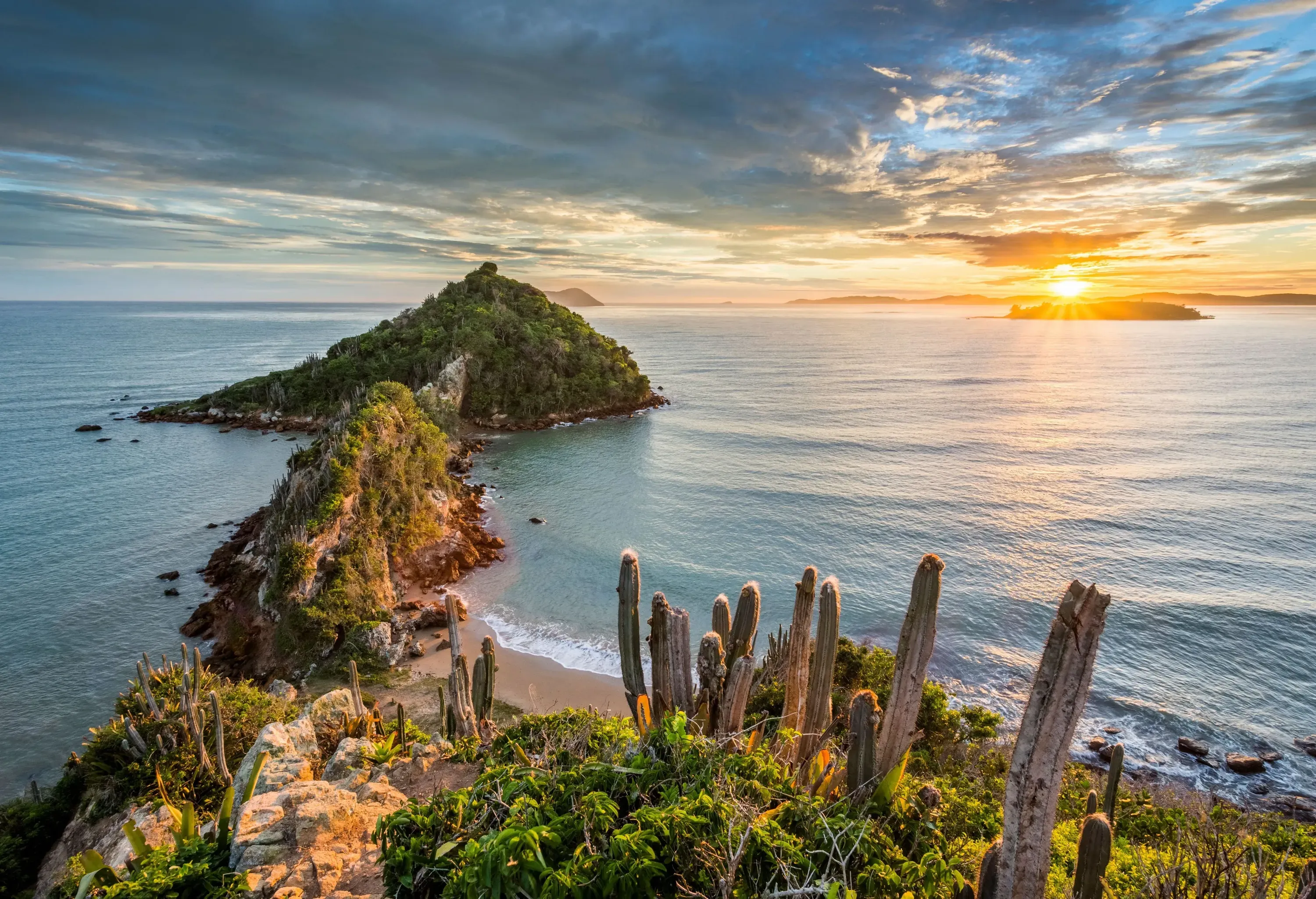 A tranquil morning on the beach with the sun slowly rising over the horizon.