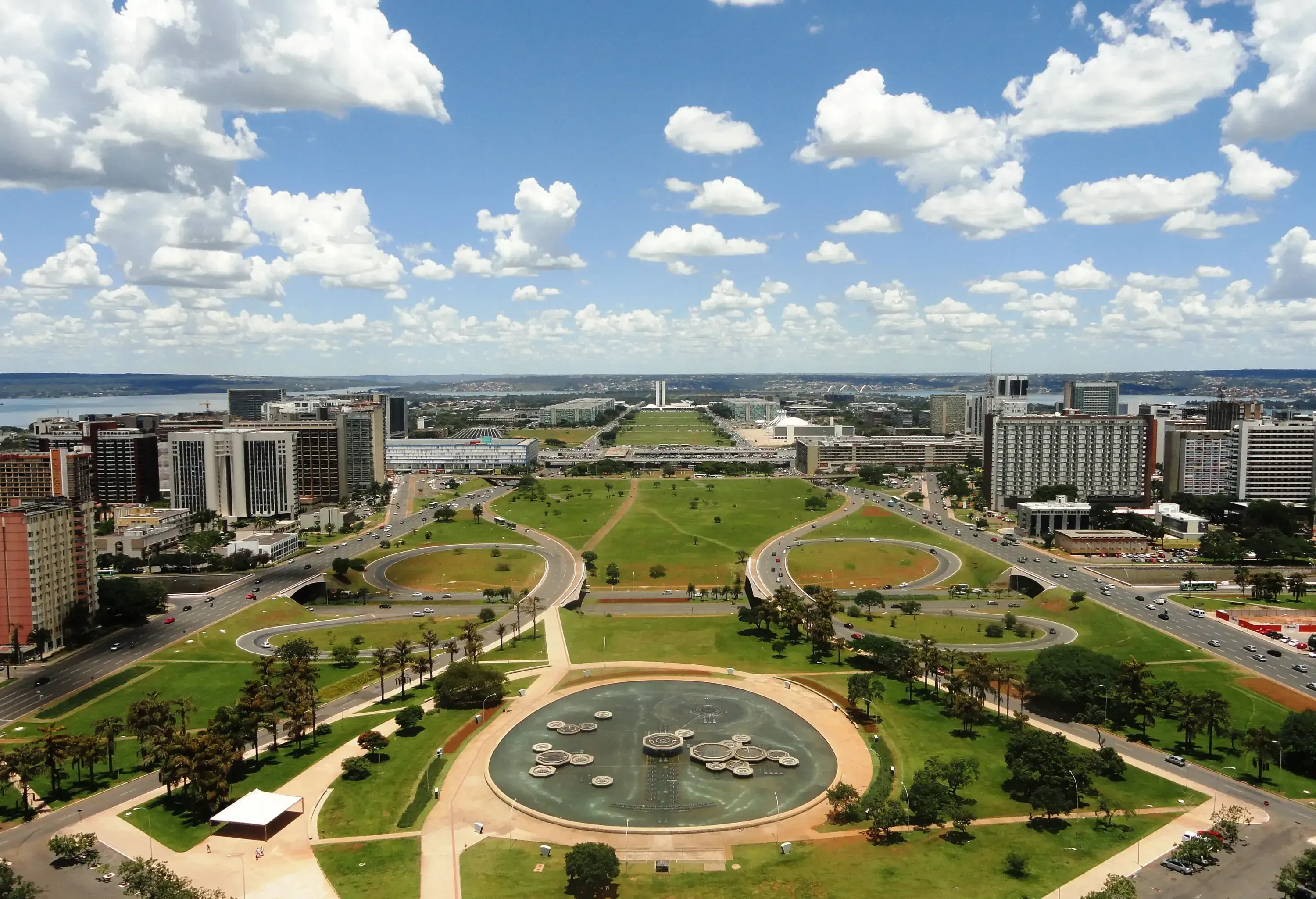Aerial view of a massive park in the centre of modern buildings against the cloudy blue sky.